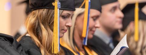Dean Mike Decelle hands student diploma on stage